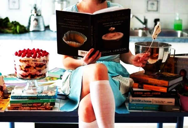 девушка читает кулинарную книгу на столе 
