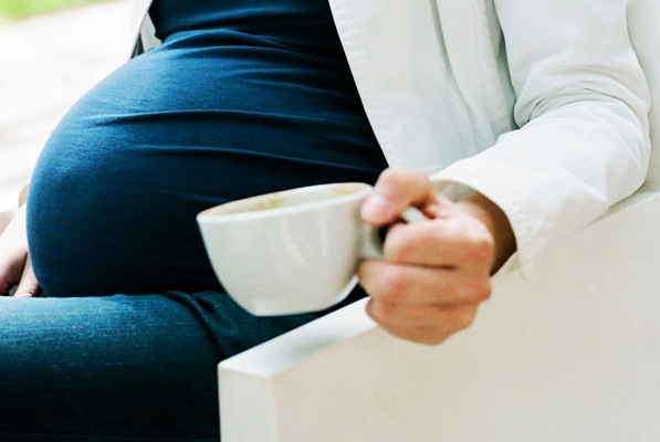 беременная пьет чай с чашки 